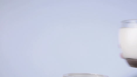 hand taking away glass of milk