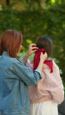 friends styling hair with red ribbon