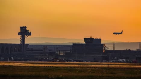 passenger plane landing in airport at sunset