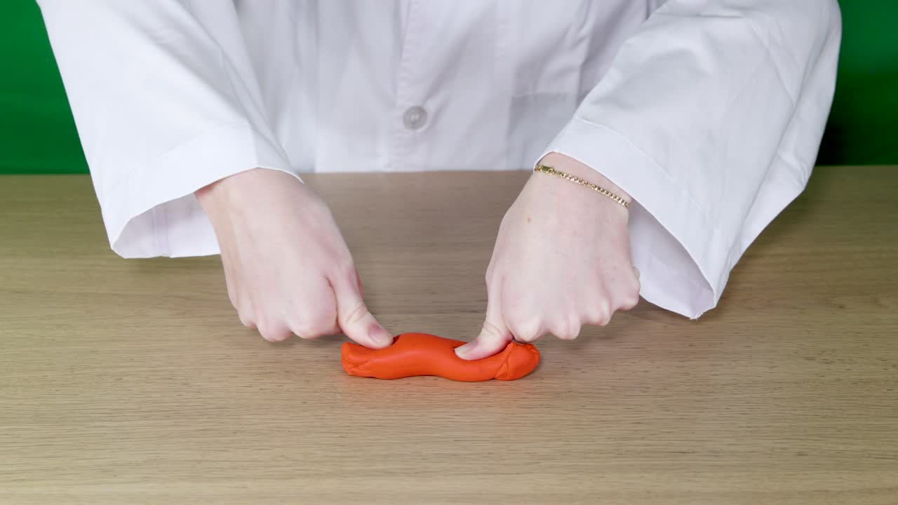 손은 물질의 성질을 보여주기 위해 점토를 조작합니다.