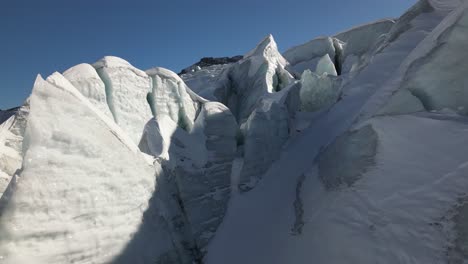 Icy-peaks-of-a-Swiss-alps-glacier-in-winter,-aerial-view,-global-warming