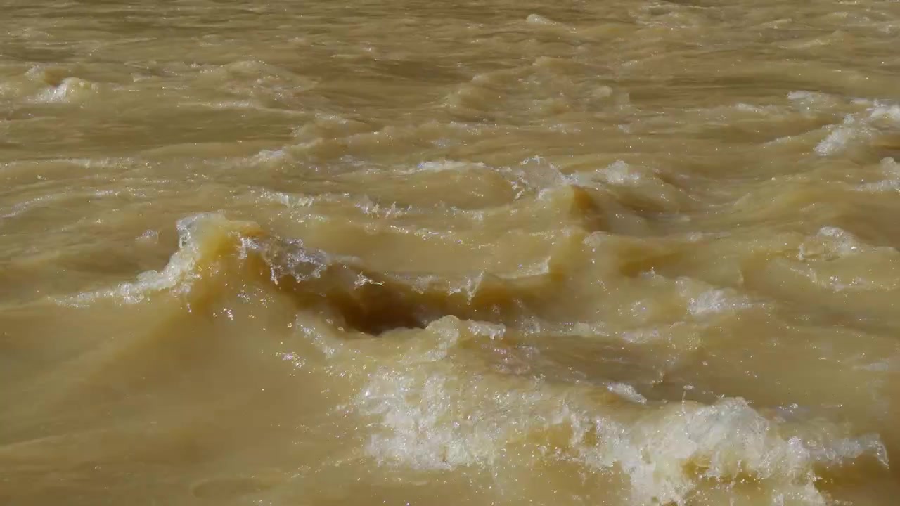 Sediment rich river water moving across the Yampa channel, whitewash churns and bounces