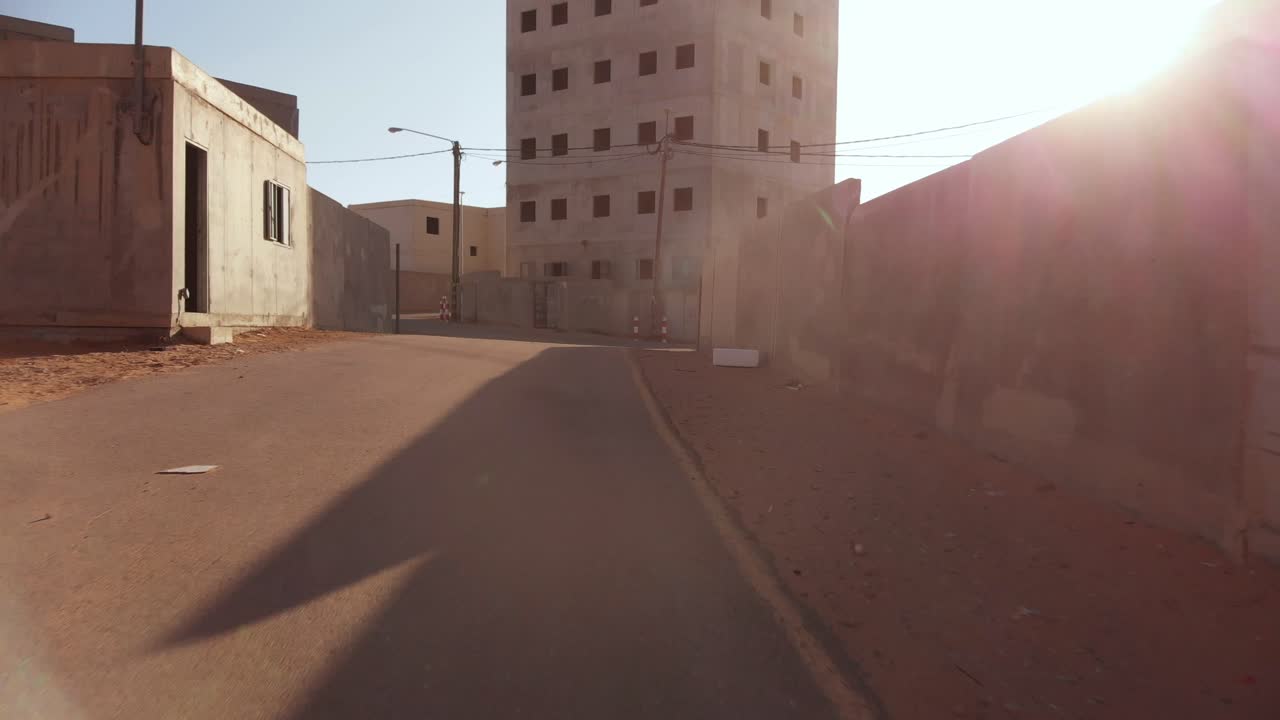 Drone FPV in una città araba vuota in Palestina vicino a Gaza si alza lentamente rivelando un grande edificio alto al mattino