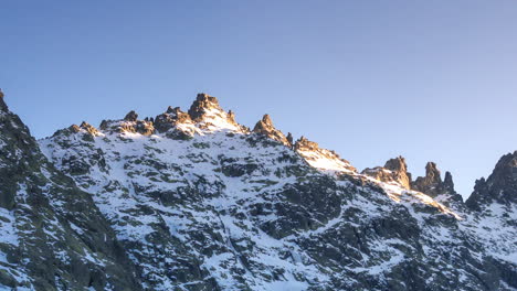 Sunset-at-Laguna-Grande-de-Gredos,-perfect-reflection-of-the-mountains-in-the-half-frozen-lake