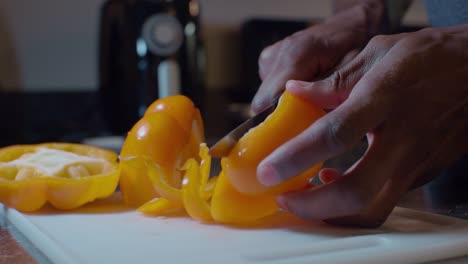 cocine el corte longitudinal de un pimiento amarillo fresco en la tabla de cortar