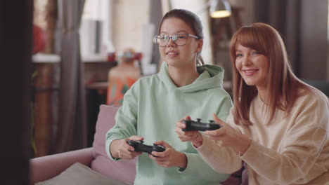 beautiful mother and daughter playing console game at home