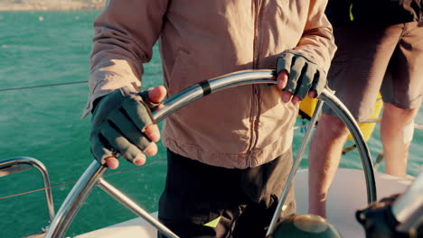 hands, sailing and steering wheel in boat