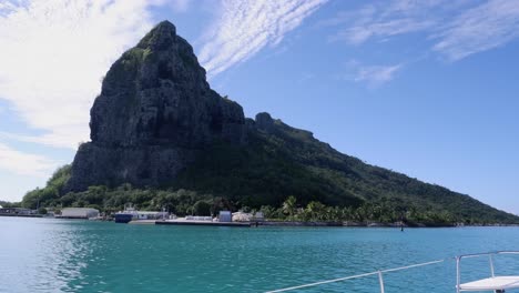 vista desde un velero: montaña rocosa empinada en una pequeña isla polinesia