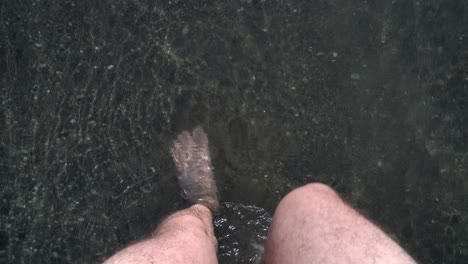 pov of a man standing on a beach, waves hitting