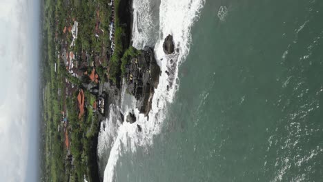formato vertical aéreo: templo tanah lot en la escarpada costa rocosa de bali