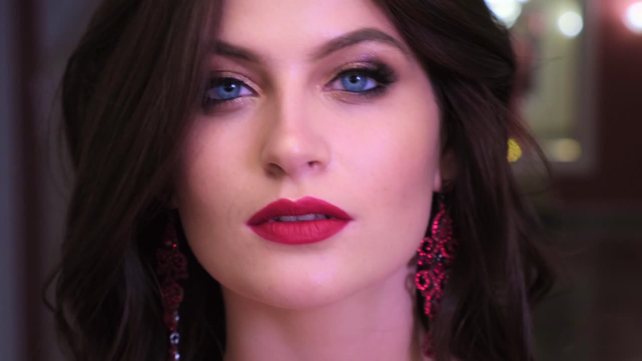 A Close-Up Portrait Capturing Intense Blue Eyes and Striking Red Lips, Highlighting Beauty and Elegance in a Glamorous Setting
