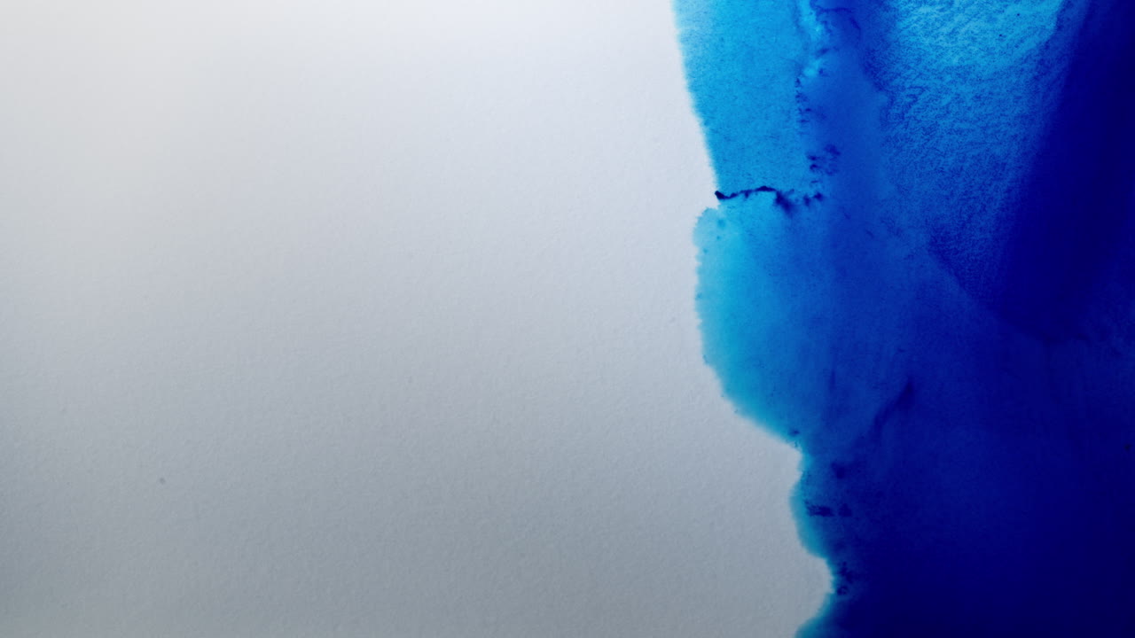 Blue ink spreading in water, macro shot showcasing delicate fluid movements