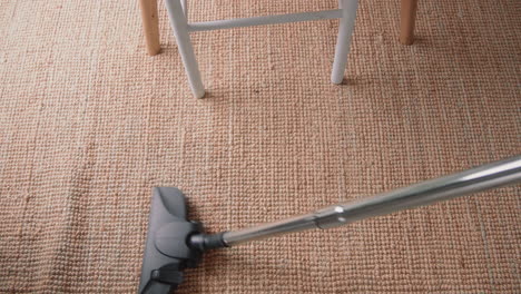 young male cleaning the house with a vacuum cleaner cleaning the carpet top shot