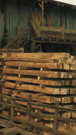 madera apilada por un viejo granero de madera