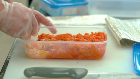 el cocinero prepara el relleno para la salsa para decorar los rollos japoneses