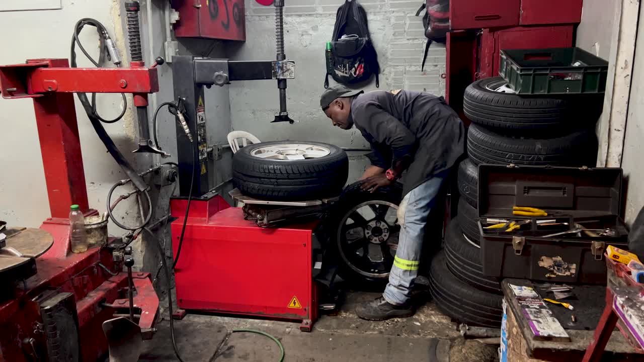 hombre de trabajo duro arreglando una rueda en su taller_tire_service station