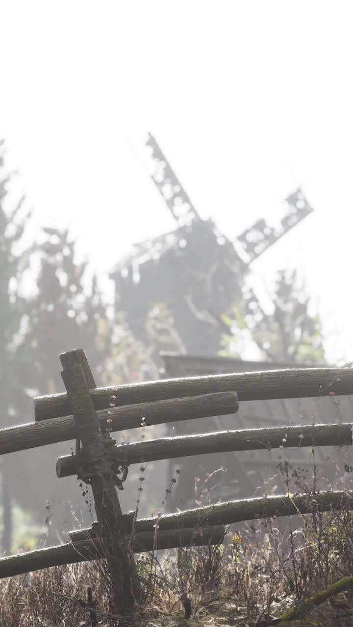 오래된 풍차와 울타리가 있는 안개가 가득한 시골