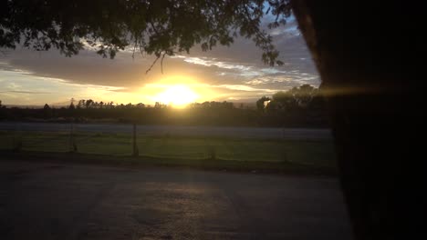 Revelación-En-Cámara-Lenta-De-Una-Hermosa-Puesta-De-Sol-En-África-Con-Una-Carretera-Vacía-En-Primer-Plano