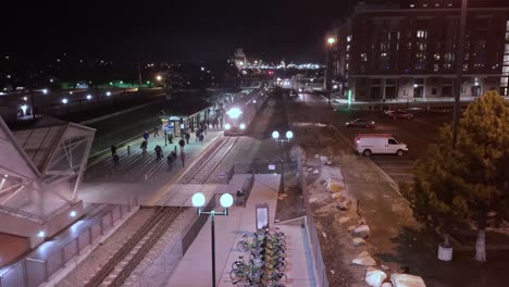 early morning or darkness time lapse of a commuter train arriving at the station and people going to and from work