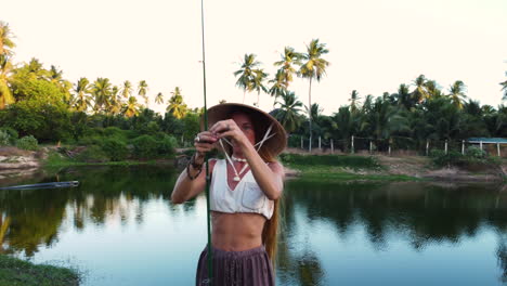 Woman-with-typical-Vietnamese-conical-hat-preparing-fishing-rod