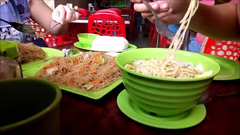 antipolo city, philippines – july 18, 2019: time lapse video of wanton noodle soup and pancit bihon being consumed by a customer inside a restaurant.