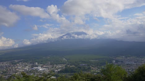 Fangen-Sie-Die-Essenz-Des-Fuji-Berges-Bei-Tageslicht-In-Diesem-Filmischen-Zeitraffer-Ein,-Eingerahmt-Von-Einer-Ausgedehnten-Wolke,-Die-Die-Stadt-Darunter-Enthüllt