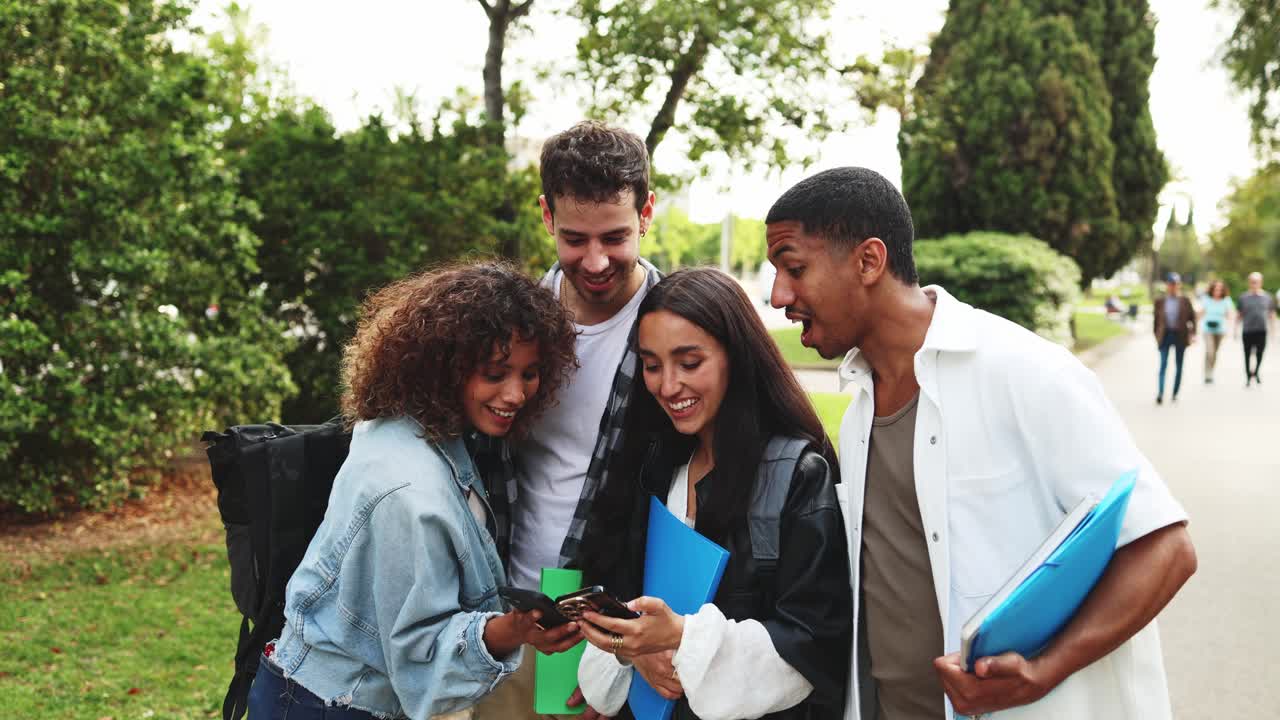 Studenti felici e diversi che camminano e usano gli smartphone all'aperto