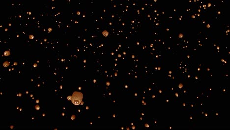 night sky filled with paper lanterns floating away at festival in slow motion