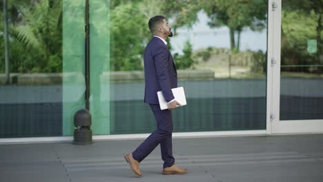 Hombre-De-Negocios-Con-Computadora-Portátil-Caminando-Por-La-Calle