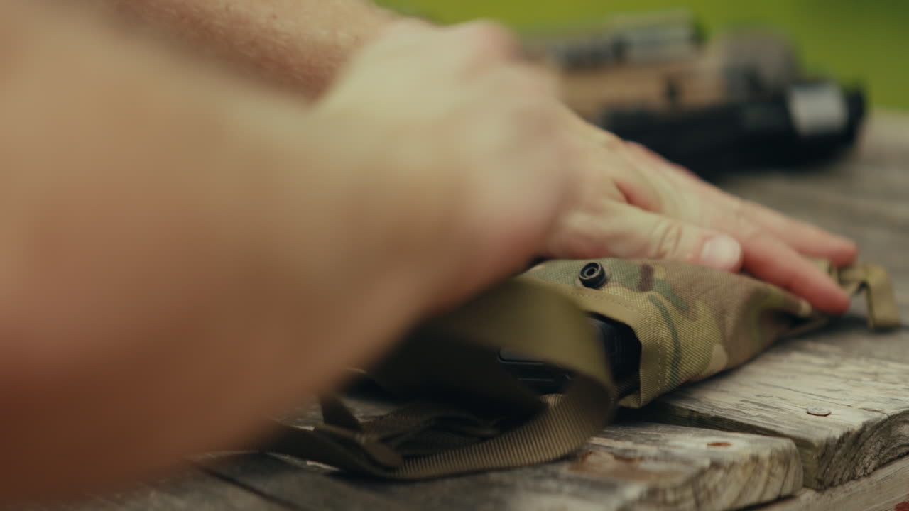 Hands interacting with camo bag on table