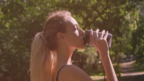 woman drinking water in a park