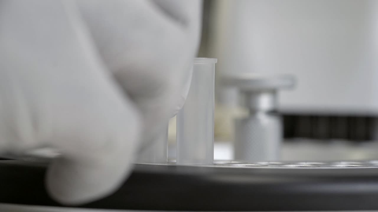 el trabajador médico tomó el tubo de ensayo en el analizador de química