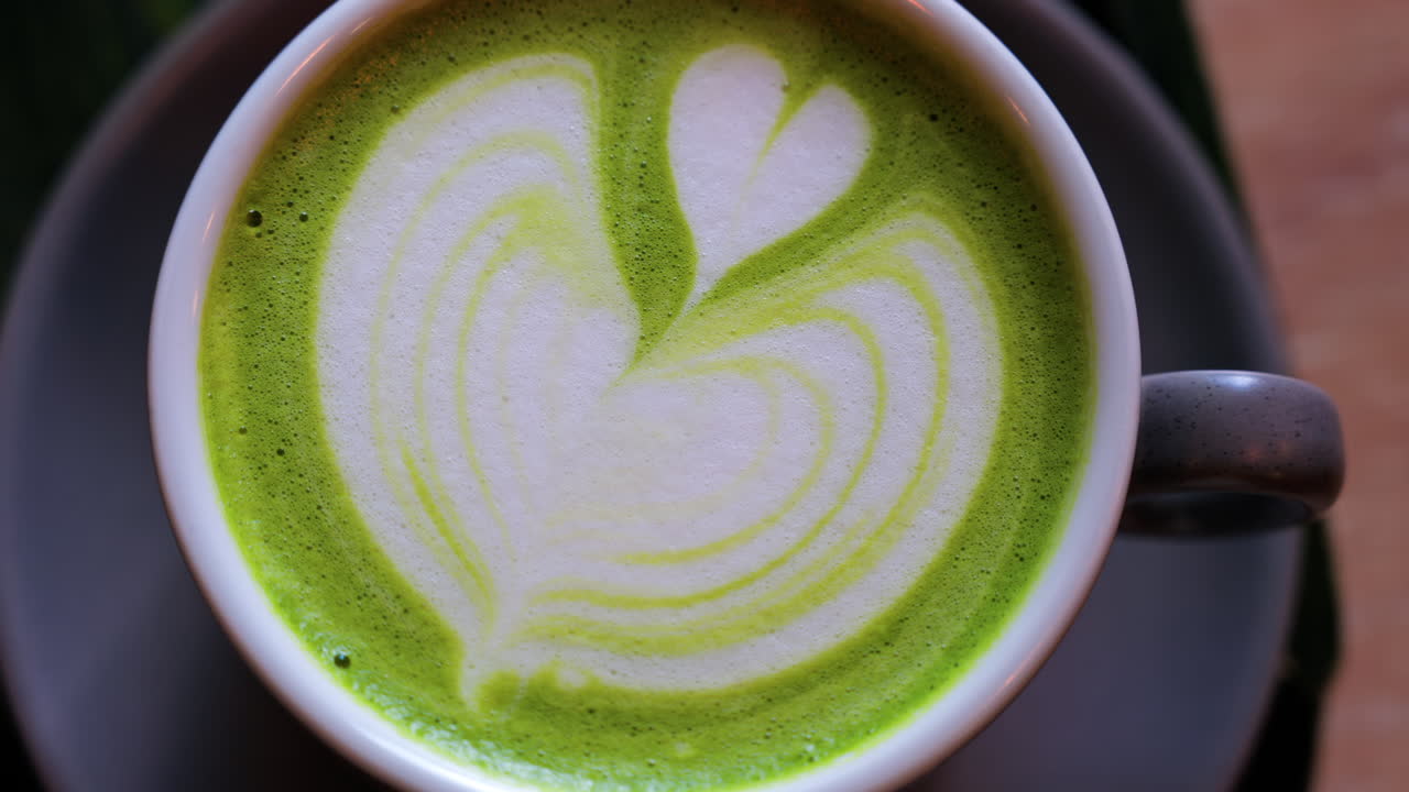Close up of a matcha latte on a little green tray at a cafe
