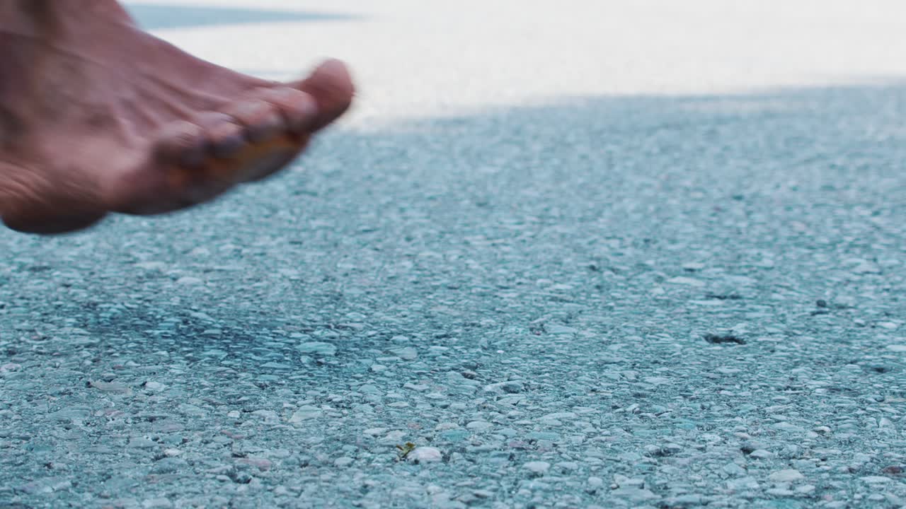 Close up of a marathon runner's foot as he runs barefoot on asphalt