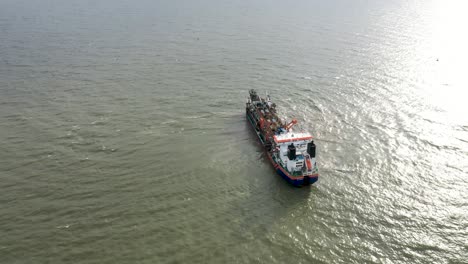 Aerial-view-approaching-a-large-container-ship-in-brazilian-ocean,-Itajai,-Santa-Catarina,-Brazil