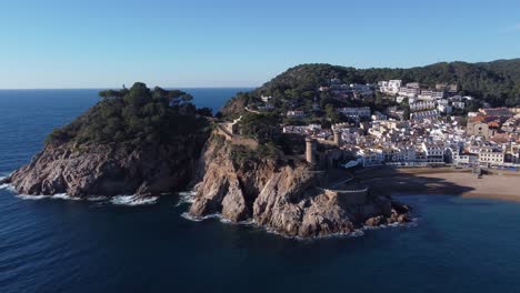 coastal town with small houses and old tower on rocky cliff