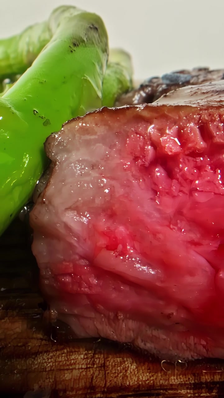 Et filmisk makrobillede, der viser en saftig medium rare oksebøf serveret med friske grønne asparges. Elementer af finere gastronomi og gourmetmadlavning.