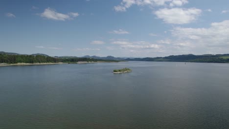 Drone-Shot-of-Small-Lonely-Island-in-the-middle-of-the-Lake