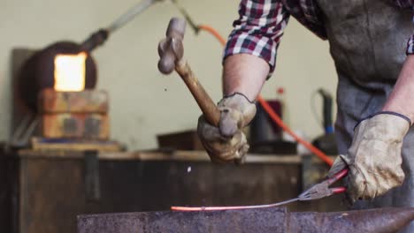 close up hands of caucasian male knife maker in workshop making knife