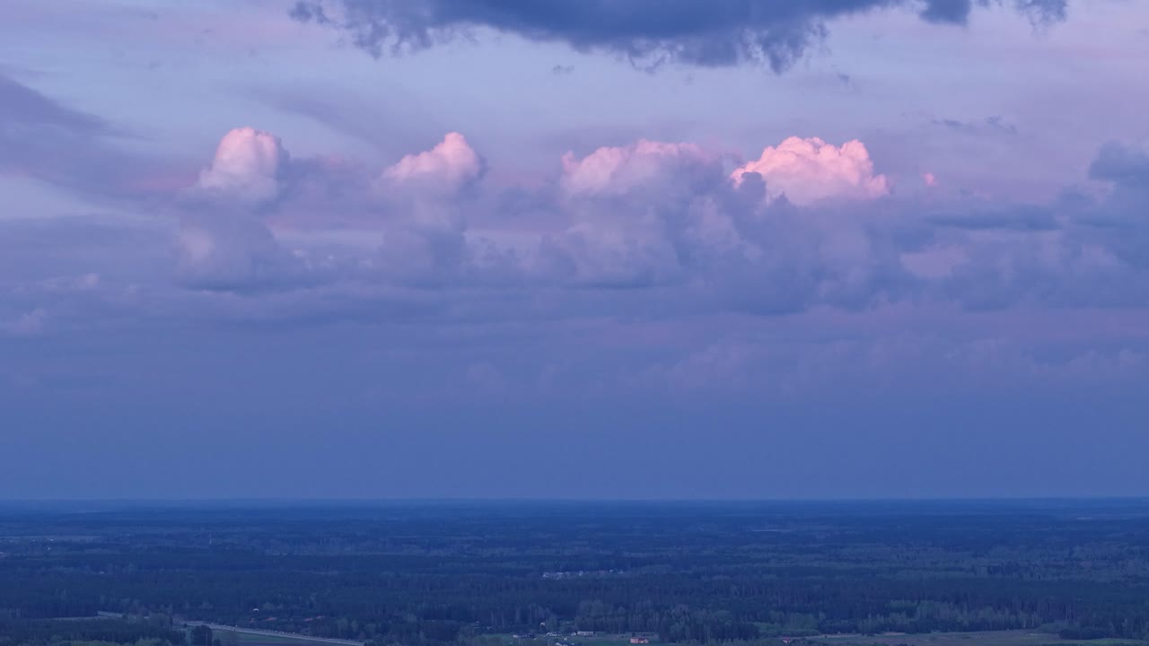 White fluffy clouds with sunset glow, time-lapse view