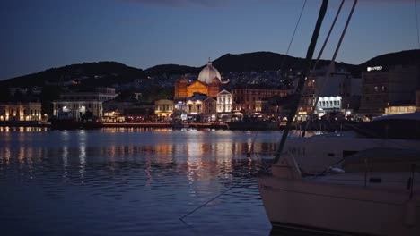 mytilene city on the greek island of lesbos with greek orthodox church saint therapon building in view at night, handheld gimbal shot