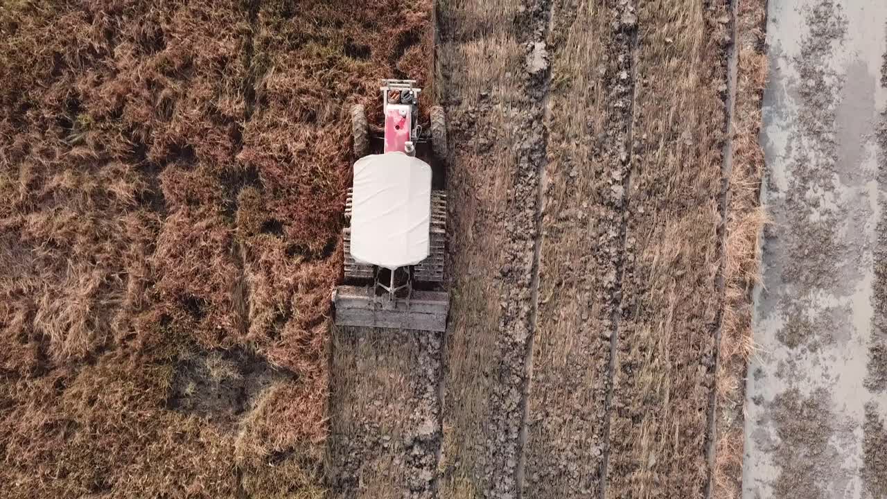 Tractor plowing in paddy field before cultivation at Malaysia.