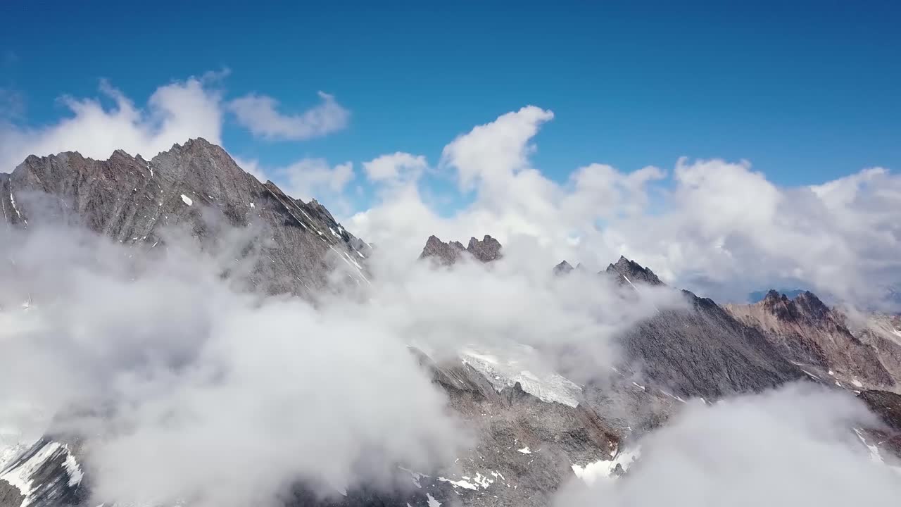 여름에 구름과 함께 스위스 알프스의 예리한 산악 범위의 공중 여행