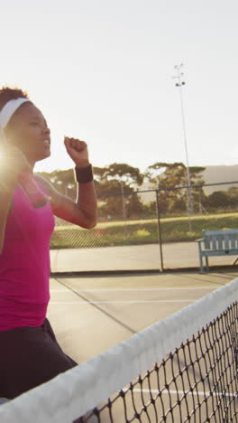 video de una feliz jugadora de tenis afroamericana sosteniendo una raqueta y golpeando la pelota