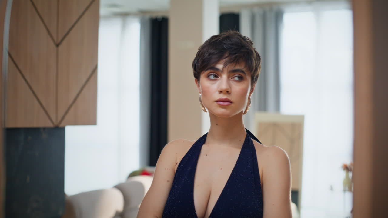 Brunetta sognante si guarda allo specchio in primo piano. Elegante modella che riflette sulla propria immagine.