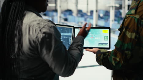 close up of military data center colleagues looking at radar software