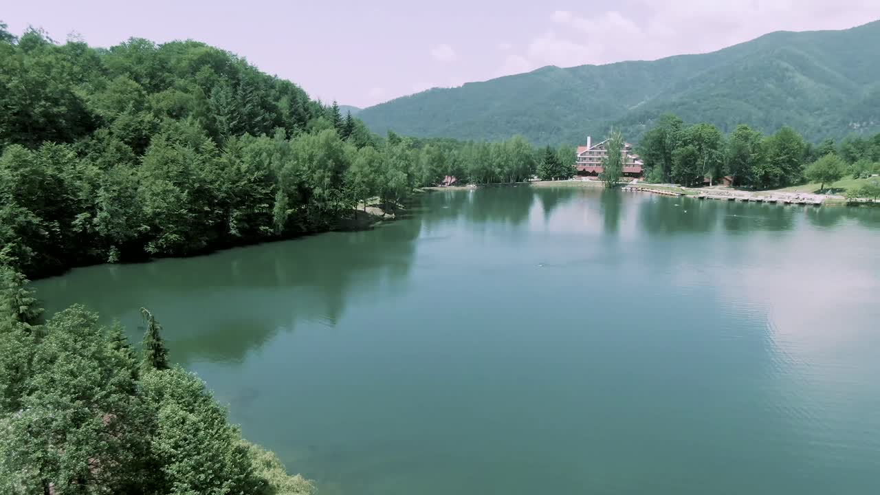 Aerial shot reveals the mountains behind the Bodi lake in Maramures, Romania