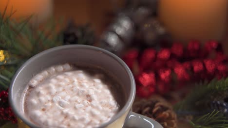 un clip en bucle de malvaviscos arremolinándose en una taza de chocolate caliente en un ambiente festivo de vacaciones de navidad