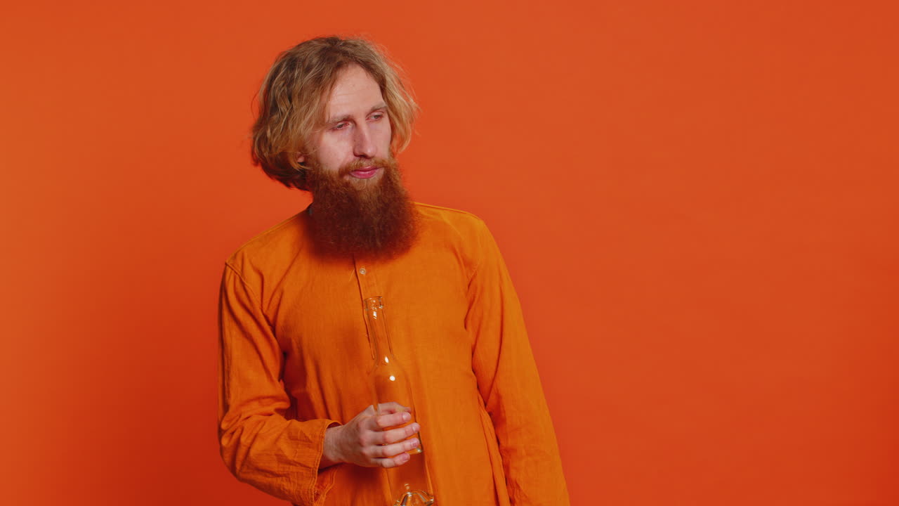 Drunk Caucasian man after party drinks vodka beverage from bottle, celebrating victory win addiction