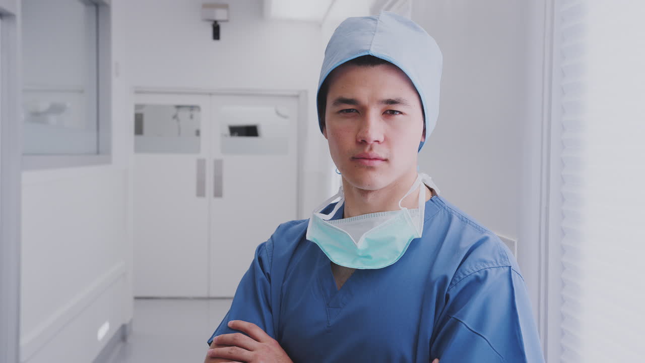 retrato de un cirujano de sexo masculino con exfoliantes y máscara de pie en el pasillo del hospital